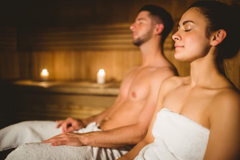 Happy couple enjoying the sauna together at the spa