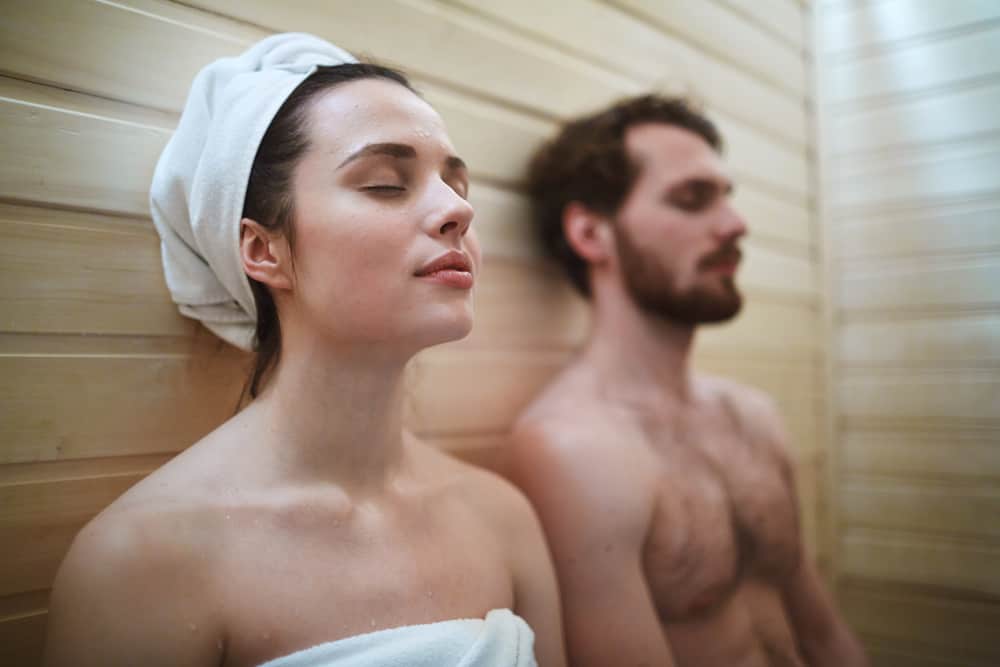 Pleased woman enjoying time in sauna with her husband