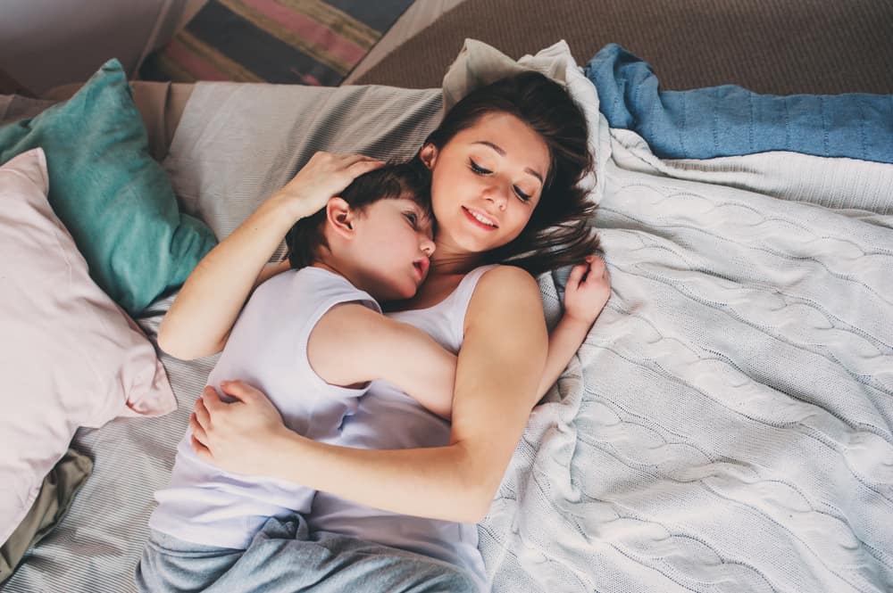 mother and child son sleeping together in bed