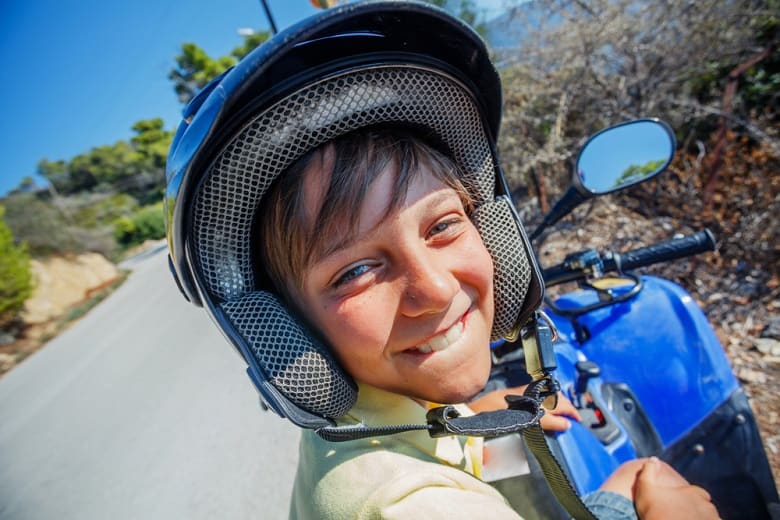 Little boy riding quad bike on Greece island